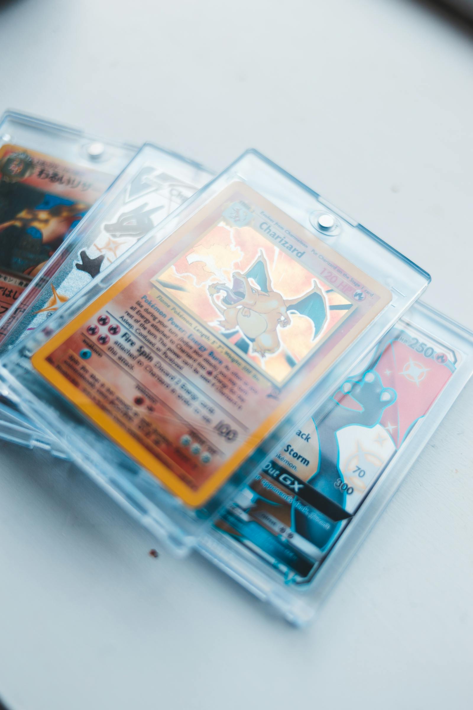 Cartes Pokémon Charizard et autres holographiques stockées dans des protections rigides type magnetic one-touch